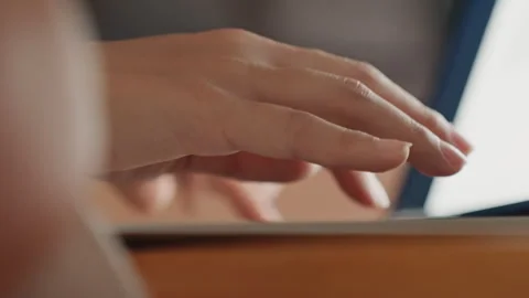 Closeup fingers tapping laptop keys hotel suite warm lamp glow creative night Stock Footage 330534940