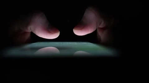 Closeup of fingers tapping smartphone screen in darkness with soft glow reflecti Stock Footage 313842904