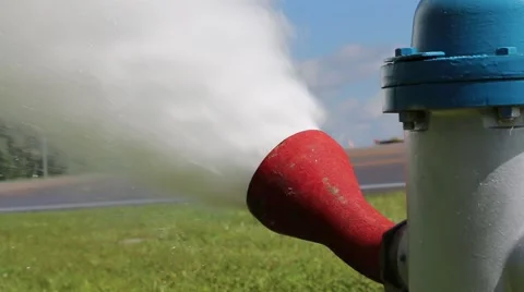 Closeup of Fire Hydrant Flushing with Cars Passing in Background Stock Footage 52888937