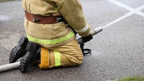 Closeup of a firefighter sitting puts out the fire with fire hose Stock Footage 122524002