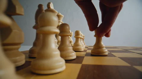 Closeup first chess move in logic game. Man fingers playing with white figures Stock Footage 332310443