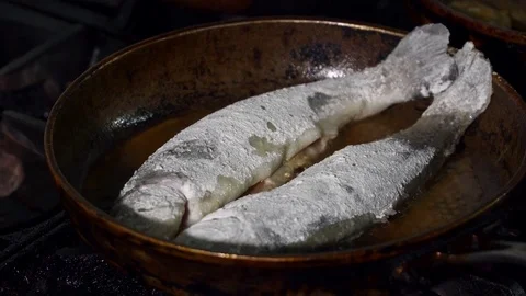 Closeup of fish in a flour fried on a pan Stock Footage 74081927