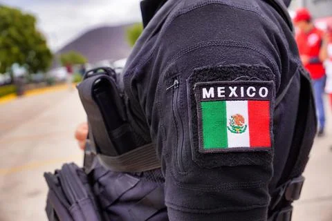 Closeup of the flag of Mexico on the arm of an uniformed Mexican guard, holding Stock Photos