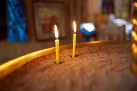 Closeup of flame of a single burning red candle light in a dark chirch mourning 스톡 사진