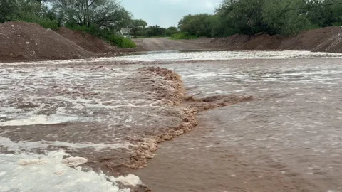 Closeup of flash flood flowing down a road in Arizona after monsoon Stock Footage 158633342
