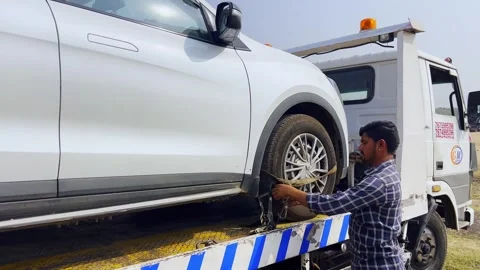 Closeup of flat bed tow truck attempt to tow and rescue broken down car Stock Footage 332422375