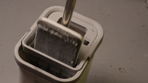Closeup of a flat mop being dipped into a bucket with water, getting ready for Stock Footage 327682722