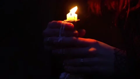 Closeup of flickering candle in hands being blown out Stock Footage 138998256
