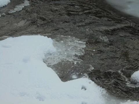 Closeup on flowing cold river during snowy winter Stock Photos