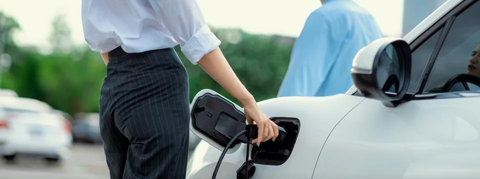 Closeup focus hand insert progressive EV charger with blurred background. Stock Photos