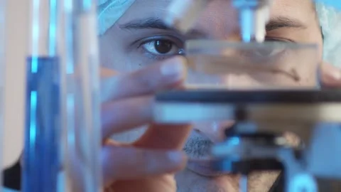 Closeup on focused eyes. The laboratory assistant puts the object of study on th Stock Footage 233031159