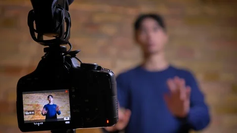 Closeup focused shoot of camera recording young korean male videoblogger talking Video stock 101624032