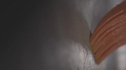 Closeup footage of spreading the melted ghee on a stainless baking tray with a Stock Footage 276794446