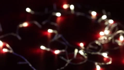 Closeup footage of a string lights lightning on a red surface in the dark with Stock Footage 260382315