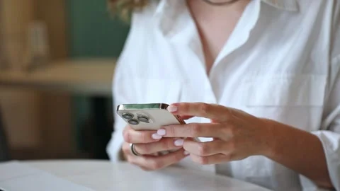 Closeup footage of young female using modern smartphone while sitting at table Stock Footage 302155761