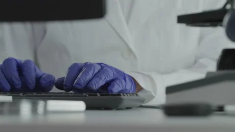 Closeup of a Forensic Scientist Typing Data Into a Computer Stock Footage 208708584