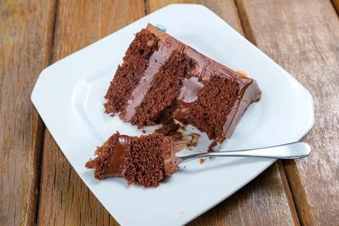Closeup of a fork with a piece of chocolate cake filled with semisweet chocol Stock Photos