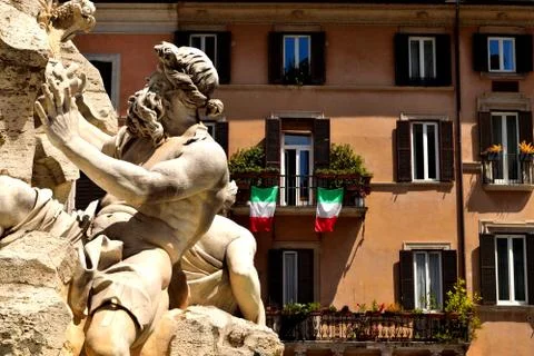 Closeup of the Four Rivers Fountain in Navona Square, Rome, and italian flags Stock Photos