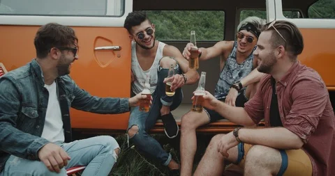 Closeup four stylish guys drinking beer at the picnic, sitting on chairs and Video stock 111892943