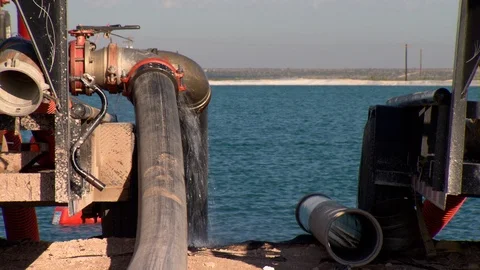 Closeup of frack pump fluid coming off of compressor near waste collection Stock Footage 125492899