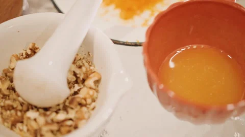 Closeup of fresh pumpkin mash and nut crushing process for pie. Chef combines Stock Footage 346403243