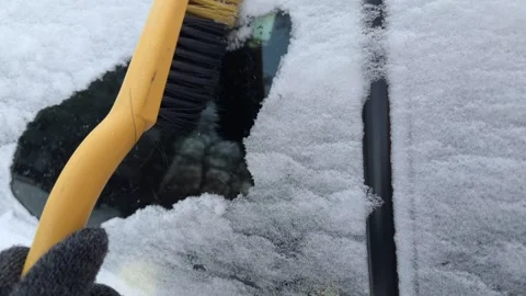 Closeup of fresh snow being cleared from a car with a brush Stock Footage 326356744