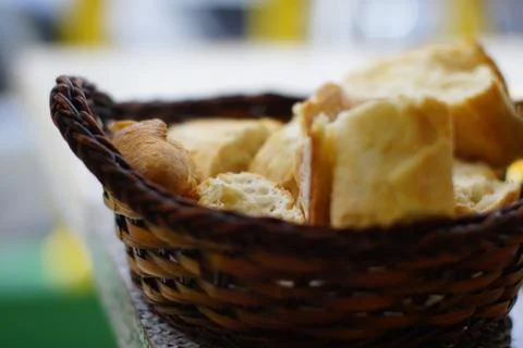 Closeup of fresh white bread for breakfast in brown wicker basket. Macro photo Stock Photos