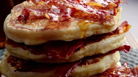Closeup of fried bacon on a stack of delicious pancakes. Vídeo Stock 336589249