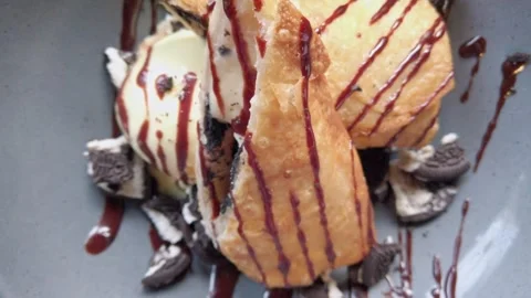 Closeup of Fried Dessert With Ice Cream Chocolate Sauce and Cookie Crumbs Stock Footage 336701085