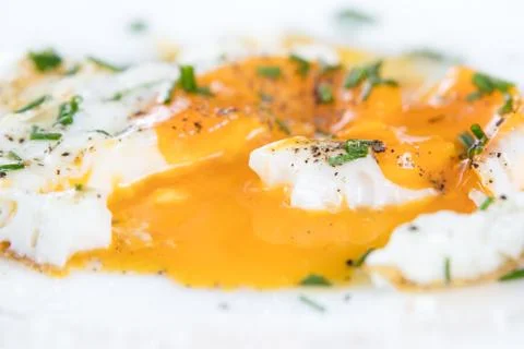 Closeup, fried egg with fluidly and liquid egg yolk on a white plate Stockfoto's