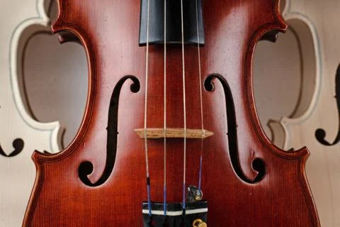 Closeup front side of completed violin,in front of half front side of raw vio Stock Photos