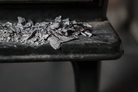 Closeup front view of ashes in front of rough, black iron oven Stock Photos