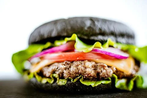 Closeup front view of black burger with artificial meat. Selective focus Stock Photos
