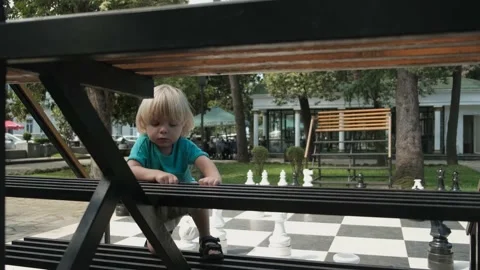 Closeup front view in slow motion as two year old boy, cautiously climbs up the Stock Footage 213570242