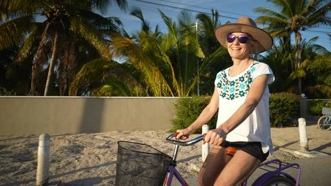Closeup front view of smiling pretty mature senior woman biking into the sun Stock Photos