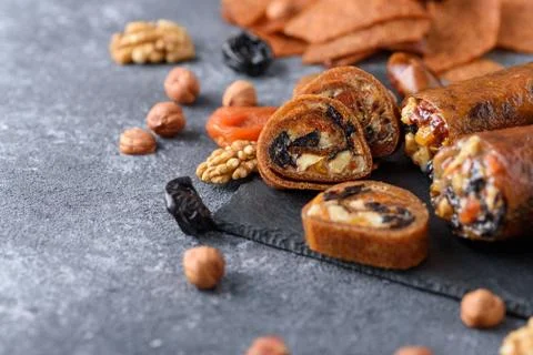 Closeup fruit roll-up with nuts, prunes, dried apricots and honey, vegetarian Stock Photos