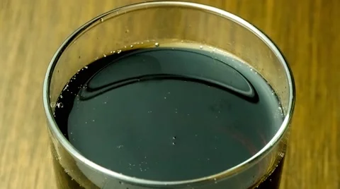Closeup of full cup of dark colored soda softdrink with carbonated gas bubble Stock Footage 62938109