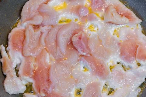 Closeup full-frame background of raw chicken breast meat just starting to roast Stock Photos
