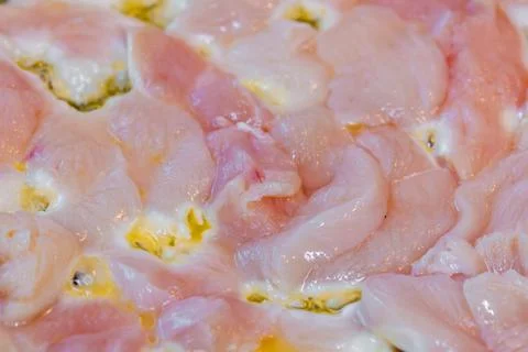 Closeup full-frame background of raw chicken breast meat just starting to roast Stock Photos