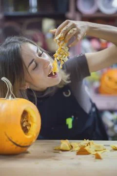 Closeup funny woman eats pumpkin for Halloween Foto stock