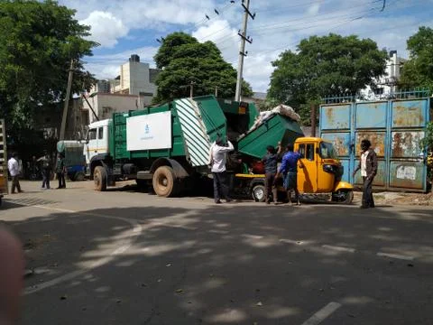 Closeup of Garbage Collecting Workers working to Unload Waste from Auto to Lo Foto stock