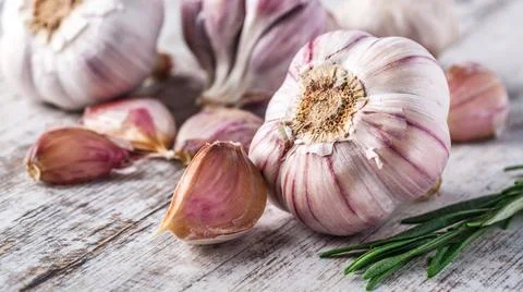 Closeup of Garlic bulbs on wooden table with garlics blur background. Stock Photos