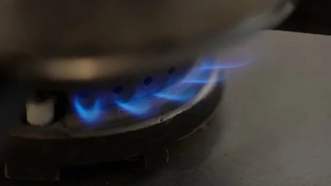 Closeup of gas fire under pot in kitchen. Blue gas flames burning Stock Footage 173446995