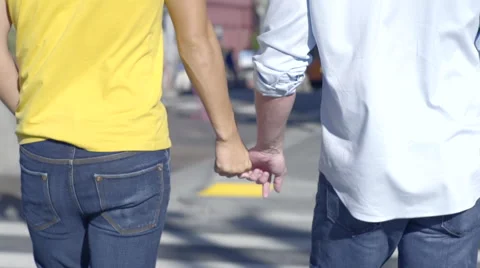 Closeup Of Gay Couple Holding Hands And Walking Across The Street In City Stock Footage