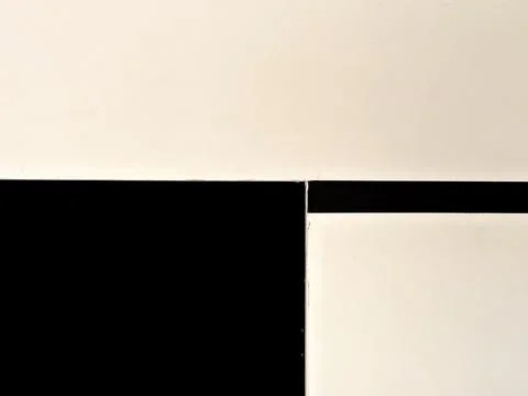 Closeup of geometric rectangular shapes on a black and beige wall 스톡 사진