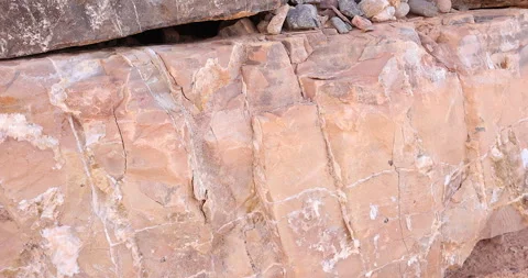 Closeup gimbal pull back of light multi color pink rock with layers of minerals Stock Footage 316409102