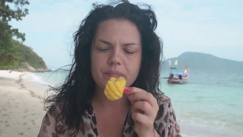Closeup girl eats pineapple fruit on sand beach, Bon island Thailand, on Stock Footage 84823187