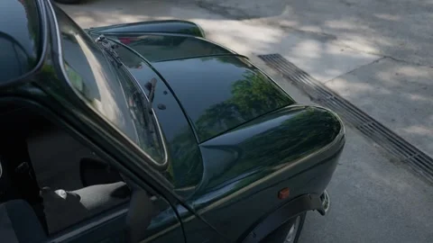 Closeup of glossy dark green classic car roof and rear window Stock Footage 337913257