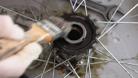 Closeup of a gloved hand cleans the rear hub of a bicycle wheel. Wash bike parts Stock Footage 115507651