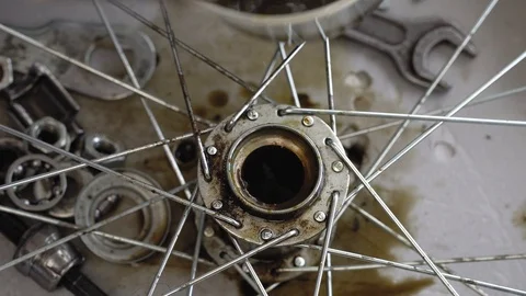 Closeup of a gloved hand cleans the rear hub of a bicycle wheel. Wash bike parts Stock Footage 115507718